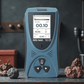 Portable radiation detector with LCD screen displaying dose rate and measurement data.